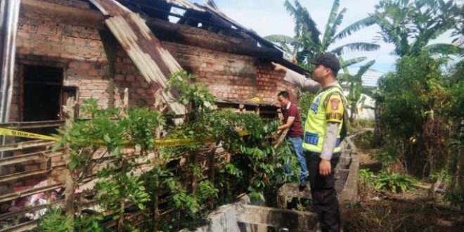 Petugas dari Polsek Jarai, sedang berada di lokasi rumah yang terbakar di Desa Aromantai, Kabupaten Lahat, hari Kamis tanggal 9 Februari 2023.