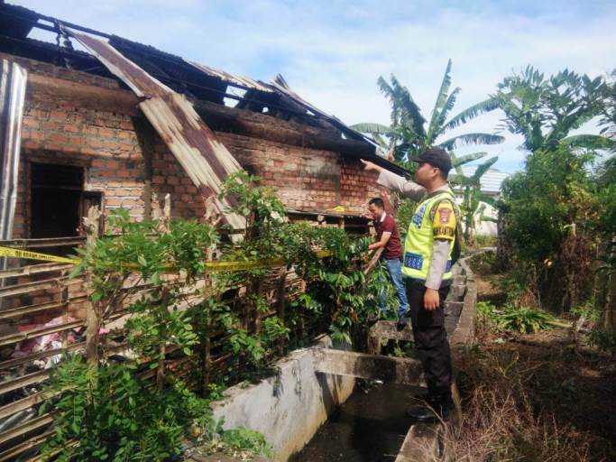 Petugas dari Polsek Jarai, sedang berada di lokasi rumah yang terbakar di Desa Aromantai, Kabupaten Lahat, hari Kamis tanggal 9 Februari 2023.