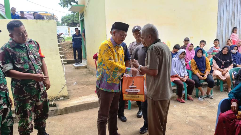 Perwakilan PT. PBSA, Drs. Tamrin, menyerahkan bantuan paket makanan dan kebutuhan pokok kepada warga di Sungai Angit, Kecamatan Babat Toman, Kabupaten Musi Banyuasin.