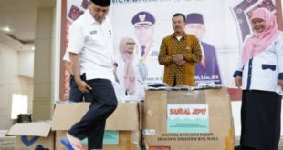Pj. Bupati Kabupaten Musi Banyuasin, H. Apriyadi Mahmud, menggunakan langsung sendal jepit produksi petani karet di Kecamatan Plakat Tinggi. (foto : bekisarmedia.id/arba'a)