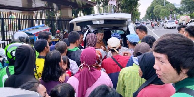 Anggota DPRD Provinsi Sumatera Selatan, Chairul S. Matdiah, membagikan nasi bungkus kepada pengendara dan masyarakat yang melintas di Jalan POM IX, Palembang, hari Minggu tanggal 31 Maret 2024. (bekisarmedia.id/sikumbang hasan)
