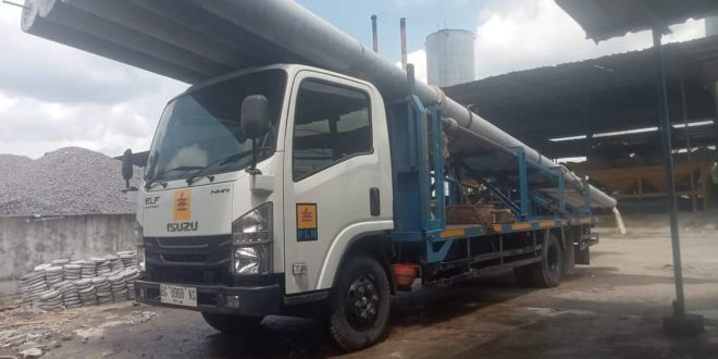 Tiang yang akan digunakan sebagai sarana menghadirkan aliran listrik di Kabupaten Musi Banyuasin, diangkut menggunakan alat berat. (bekisarmedia.id/eka sahputra)