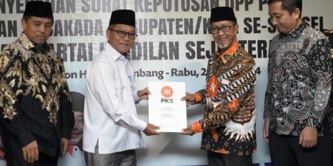 Ketua Majelis Pertimbangan Wilayah (MPW) PKS Provinsi Sumatera Selatan (Sumsel), K.H. Tol'at Wafa Ahmad, menyerahkan Surat Keputusan (SK) kepada H. Apriyadi Mahmud, pada hari Rabu siang, tanggal 26 Juni 2024 di Hotel Excelton, Palembang. (Bekisar Media / Angga Putra)
