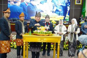 Pj. Bupati Kabupaten Musi Banyuasin, Sandi Fahlepi, memotong tumpeng pada perayaan Hari Ulang Tahun (HUT) Kabupaten Musi Banyuasin (Muba) ke 68, tergambar dalam Sidang Paripurna Dewan Perwakilan Rakyat Daerah (DPRD) yang berlangsung pada hari Sabtu pagi, tanggal 28 September 2024. (BekisarMedia.id/Eka Sahputra)