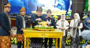 Pj. Bupati Kabupaten Musi Banyuasin, Sandi Fahlepi, memotong tumpeng pada perayaan Hari Ulang Tahun (HUT) Kabupaten Musi Banyuasin (Muba) ke 68, tergambar dalam Sidang Paripurna Dewan Perwakilan Rakyat Daerah (DPRD) yang berlangsung pada hari Sabtu pagi, tanggal 28 September 2024. (BekisarMedia.id/Eka Sahputra)