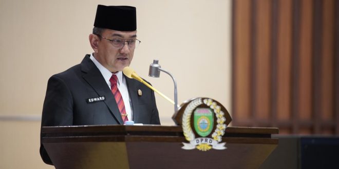 Sekretaris Daerah (Sekda) Provinsi Sumatera Selatan (Sumsel), Edward Chandra, membacakan jawaban tertulis Penjabat (Pj.) Gubernur Sumsel, Elen Setiadi, atas Pandangan Umum Fraksi-Fraksi Dewan Perwakilan Rakyat Daerah (DPRD) Sumsel terhadap Rancangan Peraturan Daerah (Raperda) Perubahan Anggaran Pendapatan dan Belanja Daerah (APBD) Sumsel Tahun Anggaran (TA) 2024 dalam Rapat Paripurna LXXXVIII (88) di Ruang Rapat Paripurna DPRD Sumsel, Jalan POM IX Kota Palembang, pada hari Rabu tanggal 28 Agustus 2024. (Bekisar Media / DPRD Sumsel)