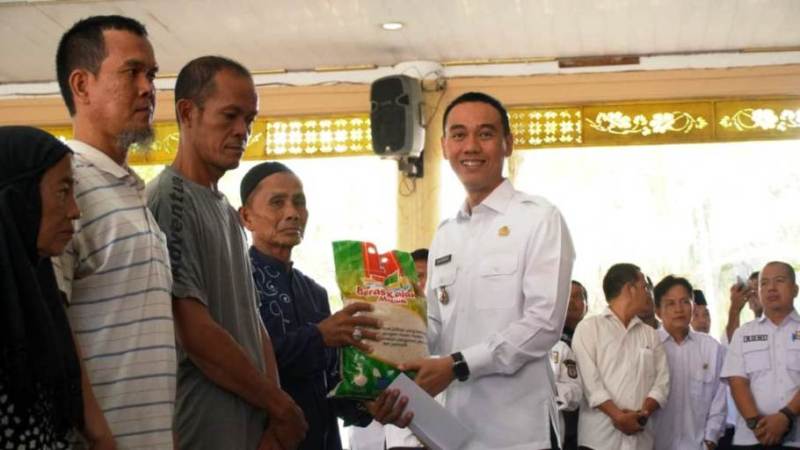 Bupati Kabupaten Ogan Komering Ilir (OKI), H. Muchendi, menyalurkan bantuan sebanyak 1.129 paket beras kepada warga kurang mampu, yang berada di dalam kecamatan Kayuagung, pada hari Rabu, tanggal 26 Maret 2025. (BEKISARMEDIA/SIKUMBANG)