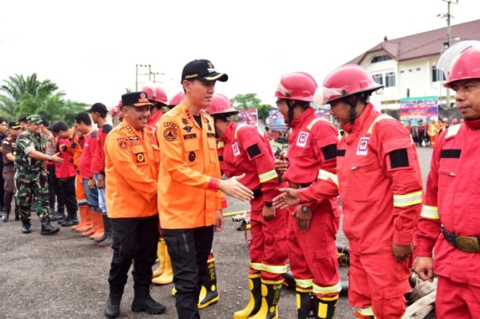 Bupati OKI, H. Muchendi Mahzareki, menghadiri Apel Kesiapsiagaan Penanggulangan Karhutla yang digelar di Halaman GOR Perahu Kajang, Kayuagung, pada hari Senin, tanggal 7 Juli 2025. (BEKISARMEDIA.ID/SIKUMBANG)