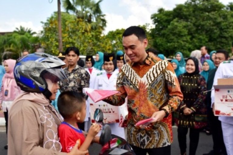 Bupati OKI, H. Muchendi Mahzareki, melakukan pembagian bendera kepada warga, sebagai bagian dari kegiatan Pemkab OKI yakni Gerakan Pembagian Bendera Merah Putih sebanyak 1.500 lembar, sebagai rangkaian peringatan Hari Ulang Tahun (HUT) Kemerdekaan Republik Indonesia ke-80 di Lapangan Segitiga Emas Kayuagung, pada hari Jum'at, tanggal 1 Agustus 2025. (BEKISARMEDIA.ID/SIKUMBANG)