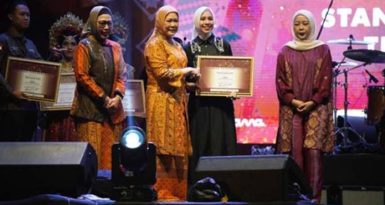 Ketua Dekranasda Sumsel, Hj. Febrita Lustia, meneyrahkan penghargaan kepada Ketua Dekranasda OKI, Hj. Ike Meilina, karena berhasil menjadi Juara I Stand terbaik dalam perhelatan Swarna Songket Nusantara tahun 2025 di Pelataran Benteng Kuto Besak, Palembang, tanggal 1-5 Agustus 2025. (BEKISARMEDIA.ID/SIKUMBANG)