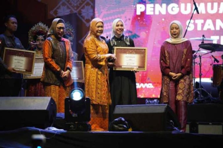 Ketua Dekranasda Sumsel, Hj. Febrita Lustia, meneyrahkan penghargaan kepada Ketua Dekranasda OKI, Hj. Ike Meilina, karena berhasil menjadi Juara I Stand terbaik dalam perhelatan Swarna Songket Nusantara tahun 2025 di Pelataran Benteng Kuto Besak, Palembang, tanggal 1-5 Agustus 2025. (BEKISARMEDIA.ID/SIKUMBANG)