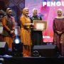 Ketua Dekranasda Sumsel, Hj. Febrita Lustia, meneyrahkan penghargaan kepada Ketua Dekranasda OKI, Hj. Ike Meilina, karena berhasil menjadi Juara I Stand terbaik dalam perhelatan Swarna Songket Nusantara tahun 2025 di Pelataran Benteng Kuto Besak, Palembang, tanggal 1-5 Agustus 2025. (BEKISARMEDIA.ID/SIKUMBANG)
