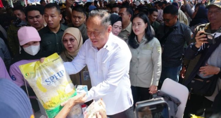 Wakil Gubernur Sumatera Selatan, Cik Ujang, menyerahkan beras SPHP kepada warga, dalam operasi pasar murah yang digelar oleh Pemerintah provinsi Sumatera Selatan. (BEKISARMEDIA.ID/SIKUMBANG)