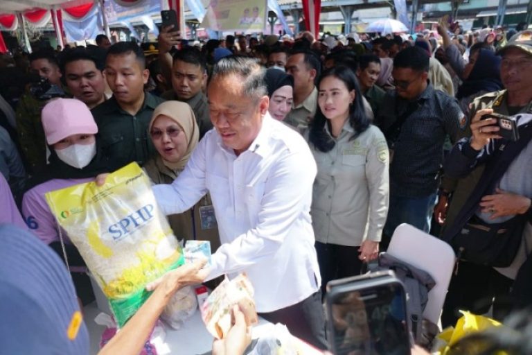 Wakil Gubernur Sumatera Selatan, Cik Ujang, menyerahkan beras SPHP kepada warga, dalam operasi pasar murah yang digelar oleh Pemerintah provinsi Sumatera Selatan. (BEKISARMEDIA.ID/SIKUMBANG)