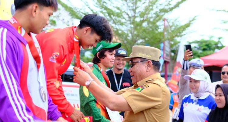 Bupati Kabupaten Muba, M. Toha, mengalungkan Medali kepada atlet yang berhasil menjadi juara pada cabang olahraga yang dipertandingan di Pekan Olahraga Provinsi Sumatera Selatan tahun 2025 di Sekayu. (BEKISARMEDIA.ID/SIKUMBANG)