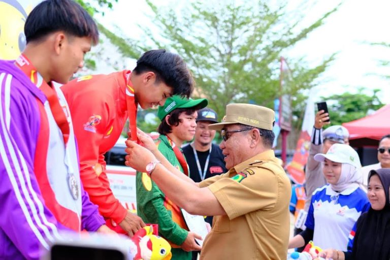 Bupati Kabupaten Muba, M. Toha, mengalungkan Medali kepada atlet yang berhasil menjadi juara pada cabang olahraga yang dipertandingan di Pekan Olahraga Provinsi Sumatera Selatan tahun 2025 di Sekayu. (BEKISARMEDIA.ID/SIKUMBANG)