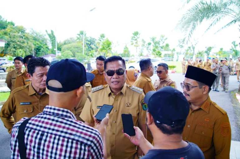 Bupati Kabupaten Musi Banyuasin, M. Toha, memberikan penjelasan kepada wartawan, setelah melakukan pengecekan fisik kendaraan operasional desa Tahap I Tahun Anggaran 2025, di Pendopoan Griya Bumi Serasan Sekate, pada hari Senin, tanggal 12 Januari 2026. (BEKISARMEDIA.ID/ANGGA)