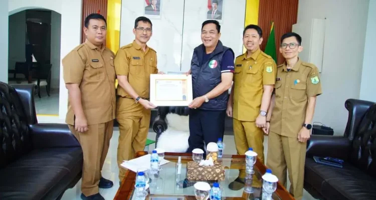 Ir. H. Pathi Riduan, S.E., A.T.D., M.M., I.P.P., secara resmi menyerahkan piagam penghargaan Indeks Keinsinyuran Daerah (IKD) Tahun 2026 kepada Bupati Muba, Toha Tohet. (FOTO : BEKISARMEDIA.ID/TRI)